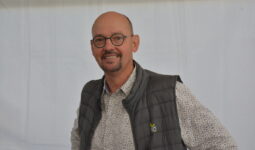 Un homme souriant avec des lunettes