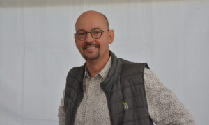 Un homme souriant avec des lunettes