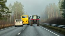 Un bus et un van en train de doubler un tracteur sur une route à 2 voies