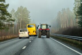 Un bus et un van en train de doubler un tracteur sur une route à 2 voies