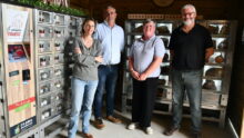 Des personnes devant des casiers pour la vente de produits