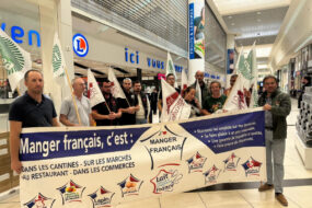 Des personnes tiennent une banderole 'Manger français' dans une GMS
