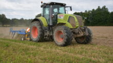 Un tracteur avec un outil attelé au travail au champ