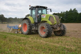 Un tracteur avec un outil attelé au travail au champ