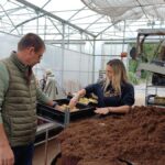 Un homme et une femme au corus d'un atelier de rempottage dans une serre