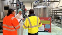 trois personnes échangeant dans une industrie agro-alimentaire