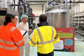 trois personnes échangeant dans une industrie agro-alimentaire