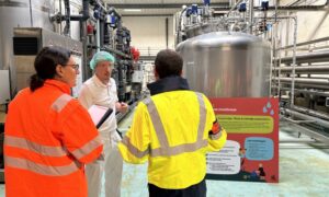 trois personnes échangeant dans une industrie agro-alimentaire