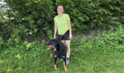 Une femme en tenue de marche avec son chien en pleine nature