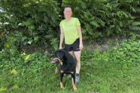 Une femme en tenue de marche avec son chien en pleine nature