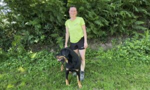 Une femme en tenue de marche avec son chien en pleine nature