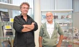 Deux personnes se tenant debout devant une vitrine d'ouvrages et de CD édités par l'association Dastum