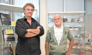 Deux personnes se tenant debout devant une vitrine d'ouvrages et de CD édités par l'association Dastum