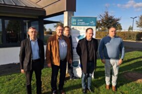 Un groupe d'homme devant un bâtiment