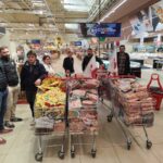 Des agriculteurs avec des caddies pleins dans un supermarché