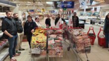 Des agriculteurs avec des caddies pleins dans un supermarché